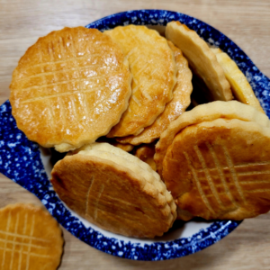Un bol breton en faïence de Quimper rempli de biscuits bretons dorés et brillants de beurre.
