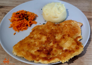 Une Wiener Schnitzel servie avec de la purée et des carottes râpées