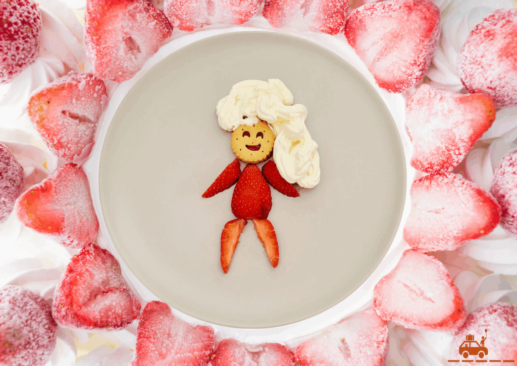 Des fraises, de la crème chantilly, une assiette contenant un bonhomme fait à partir de fraises, de crème chantilly et d'un biscuit mini BN à la fraise