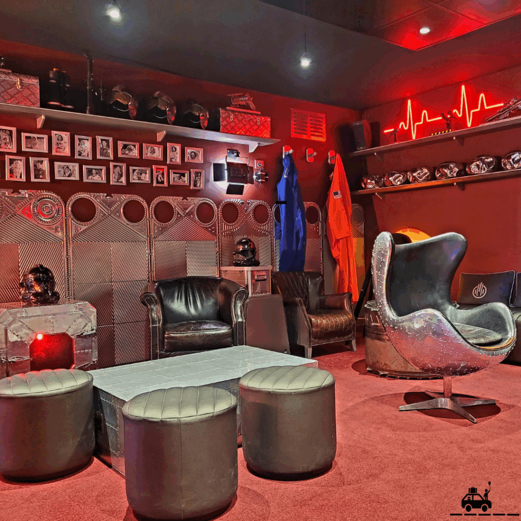 Table basse, fauteuils et décorations dans les tons rouges pour une ambiance lounge au bar des pilotes