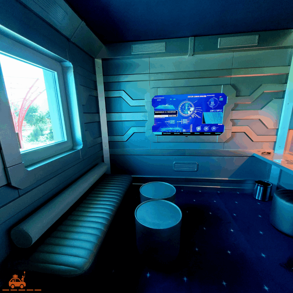 La chambre familiale du Station Cosmos : banquette, écran de télé, 2 tables basses et un bureau