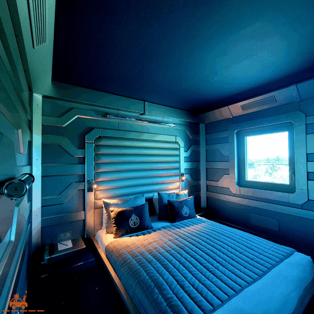 Le lit parental au style futuriste dans la chambre d'hôtel Station Cosmos