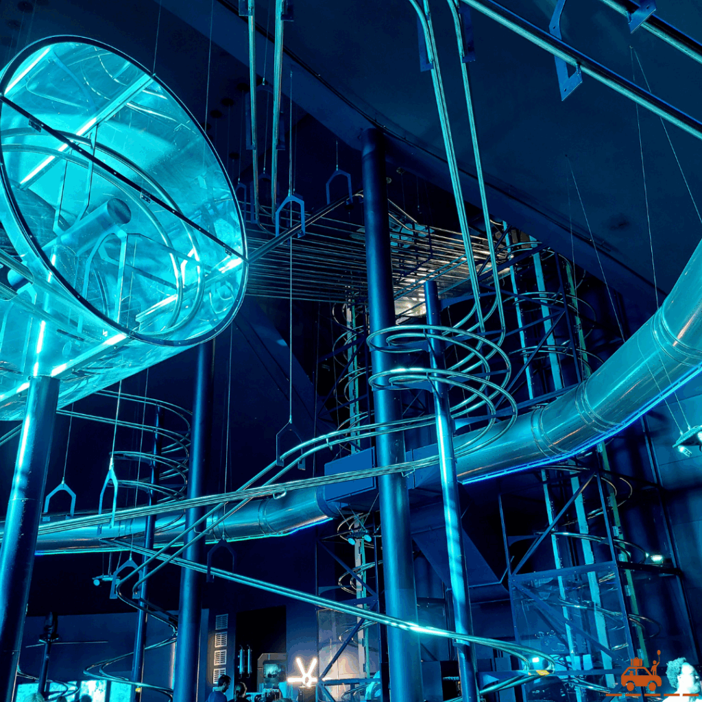 Un circuit aérien de rails suspendues, dont un looping entouré d'une protection en plastique transparente au Space Loop