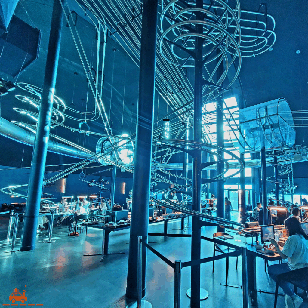 La salle du restaurant Space Loop au Futuroscope : couleur bleue et rails suspendus au plafond, grand espace