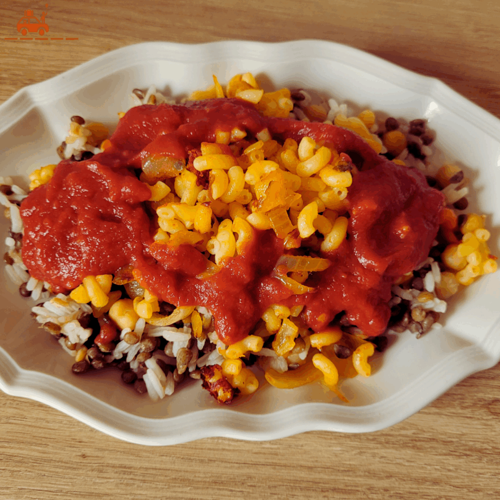 Dressage du kochari égyptien : d'abord le riz et les lentilles, puis les pates et enfin la sauce tomate et les oignons