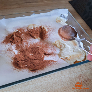 Etape 6 de la recette de tiramisu "vachement" bon - faire les tâches de la vache en cacao en saupoudrant le cacao en poudre non sucré sur les trous de la feuille de papier sulfurisé à l'aide d'une boule à thé
