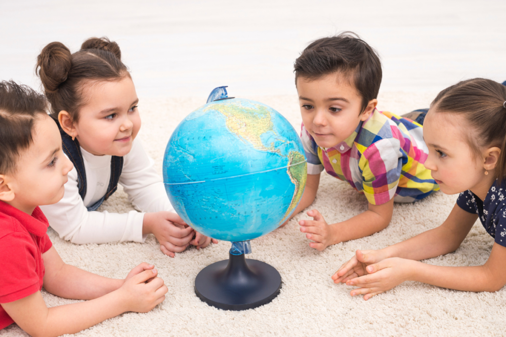 Enfants observant un globe terrestre pour découvrir les pays et cultures du monde