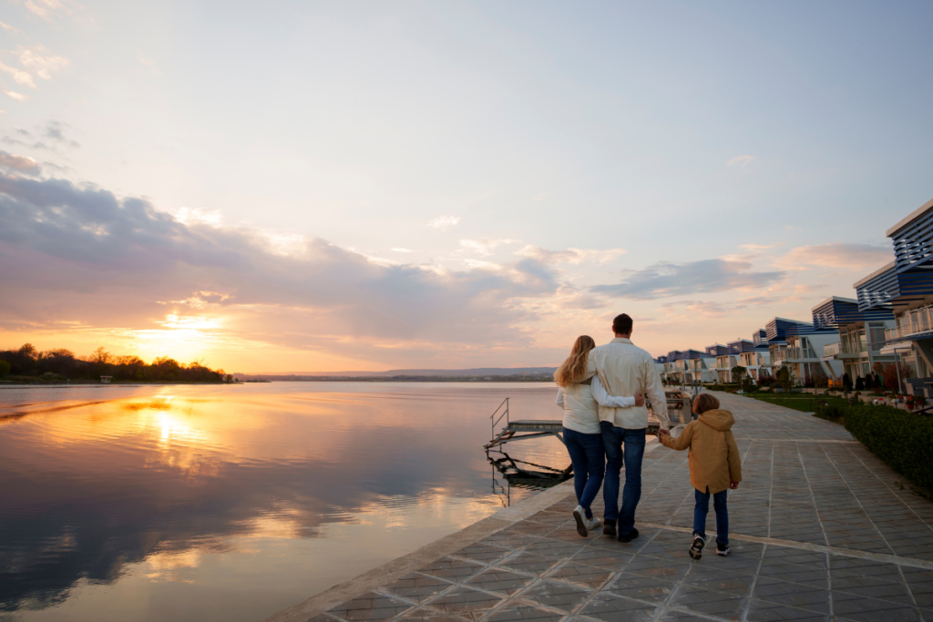 couple avec un enfant qui se promène le long de la mer à la tombée du jour