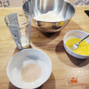 Ingrédients nécessaires à la préparation d'une pâte à tarte au sucre : farine, lait, levure boulangère, œuf battu. 