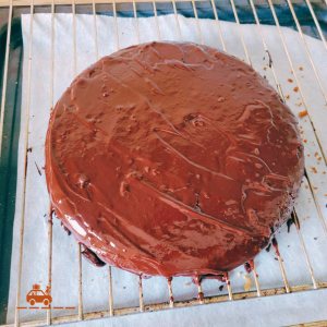Gâteau aux noix posé sur une grille et recouvert d'un glaçage au chocolat