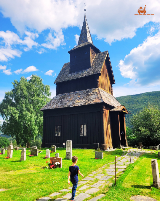 Enfant qui marche vers l'église en bois debout de Torpo en Norvège