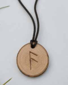 Pendentif viking fabriqué par un enfant : rune gravée sur un rondin de bois traversé par une cordelette