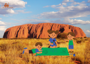 Enfants qui font une activité créative devant Uluru, dans le désert rouge en Australie