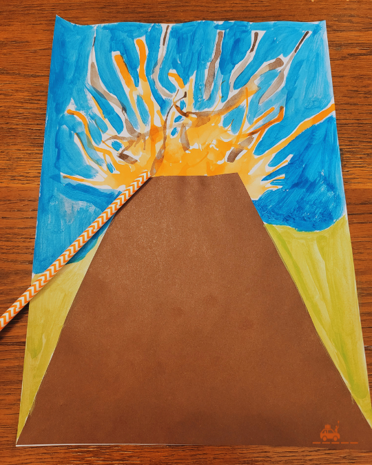 Dessin d'enfant d'un volcan réalisé à l'aide de peinture et d'une paille : une activité simple